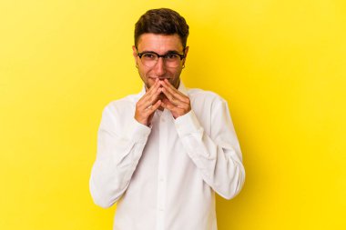 Sarı arka planda dövmeleri olan genç beyaz bir adam. Kafasında bir plan kuruyor..