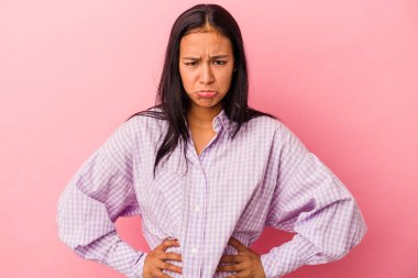 Pembe arka planda izole edilmiş genç Latin kadın üzgün, ciddi yüz, mutsuz ve hoşnutsuz hissediyor.