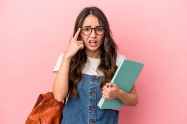 Young caucasian student woman isolated on pink background showing a disappointment gesture with forefinger.