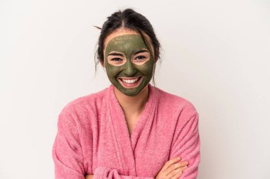 Young caucasian woman wearing a facial mask isolated on white background laughing and having fun.