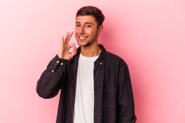 Sarı arka planda izole edilmiş beyaz dövmeli genç bir adam. Neşeli ve kendinden emin..