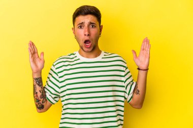 Sarı arka planda izole edilmiş dövmeleri olan genç beyaz bir adam bir fikri, ilham verici bir konsepti var..