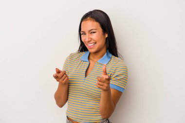 Beyaz arka planda izole edilmiş genç Latin kadın parmaklarıyla öne bakıyor..