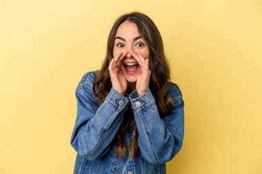 Sarı arka planda izole edilmiş genç beyaz kadın bir dedikodu söylüyor, bir şeyi haber veriyor..