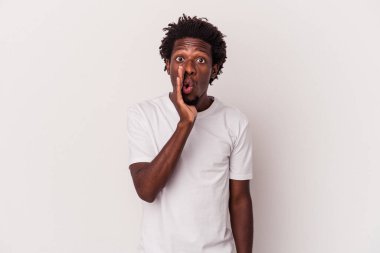 Beyaz arka planda izole edilmiş genç Afro-Amerikan bir adam gizli bir sıcak fren haberi veriyor ve kenara bakıyor.