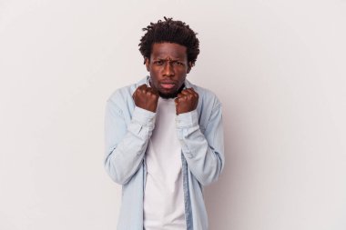 Beyaz arka planda izole edilmiş genç Afro-Amerikan adam kameraya yumruğunu gösteriyor, agresif yüz ifadesi..