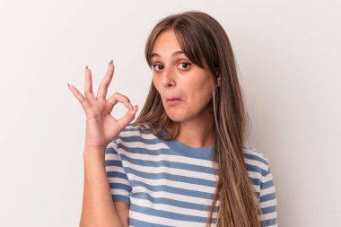 Beyaz arka planda izole edilmiş genç beyaz kadın bir göz kırptı ve elleriyle iyi bir jest yaptı..