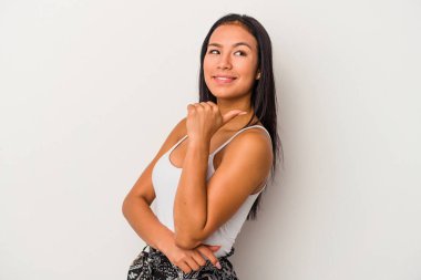 Beyaz arka planda izole edilmiş genç Latin kadın başparmak uzakta, gülüyor ve kaygısız.