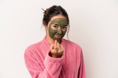 Young caucasian woman wearing a facial mask isolated on white background pointing with finger at you as if inviting come closer.