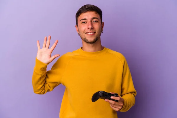 Giovane Uomo Caucasico Tenendo Controller Gioco Isolato Sfondo Viola Sorridente — Foto Stock