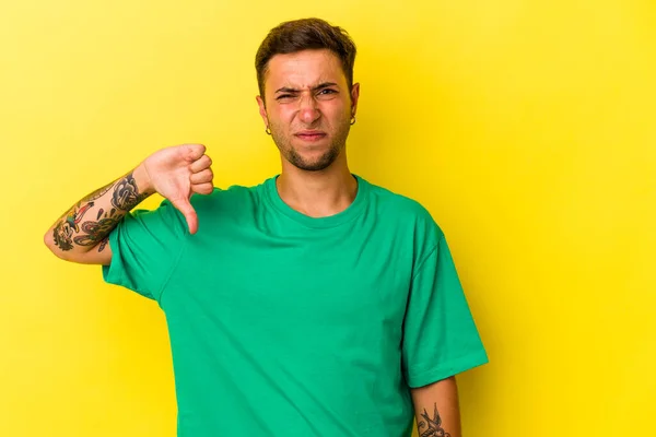 Young Caucasian Man Tattoos Isolated Yellow Background Showing Thumb Disappointment —  Fotos de Stock