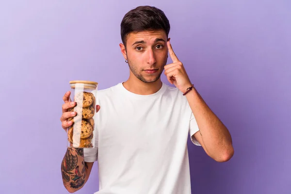 Ung Kaukasier Man Som Håller Choklad Cookies Isolerade Lila Bakgrund — Stockfoto