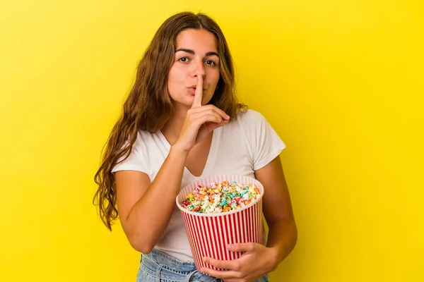 Jovem Caucasiana Segurando Uma Pipoca Isolada Fundo Amarelo Mantendo Segredo — Fotografia de Stock