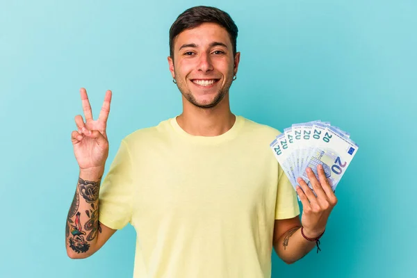 Joven Hombre Caucásico Sosteniendo Billetes Aislados Sobre Fondo Azul Mostrando — Foto de Stock
