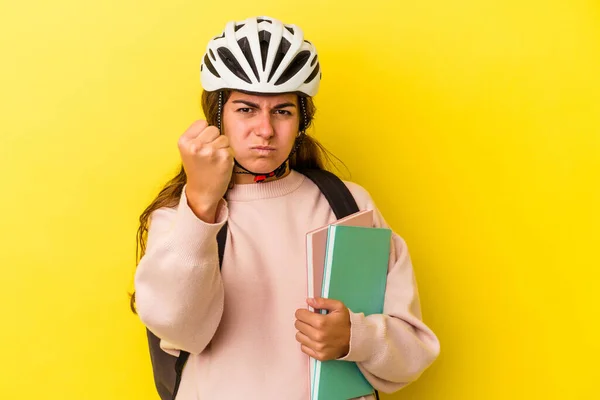 若い白人学生の女性はカメラに拳を示す黄色の背景に隔離された自転車のヘルメットを着て 積極的な顔の表情 — ストック写真