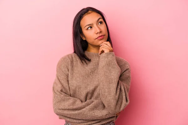 Jonge Latijnse Vrouw Geïsoleerd Roze Achtergrond Kijken Zijwaarts Met Twijfelachtige — Stockfoto