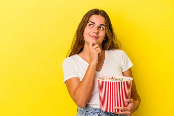 Young Caucasian Woman Holding Popcorns Isolated Yellow Background Looking Sideways — Stock Photo, Image
