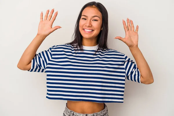 Beyaz arka planda izole edilmiş genç Latin kadın on numarayı elleriyle gösteriyor..