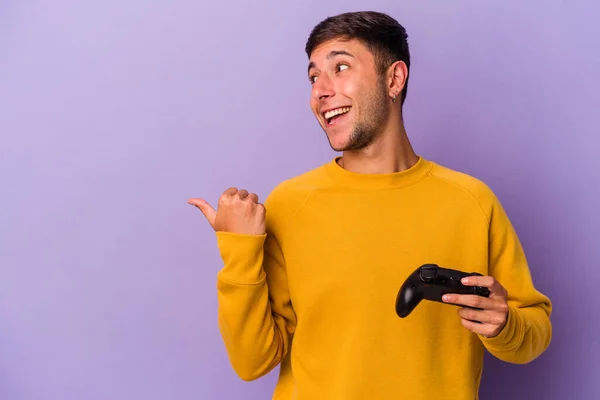 Young Caucasian Man Holding Game Controller Isolated Purple Background Points —  Fotos de Stock