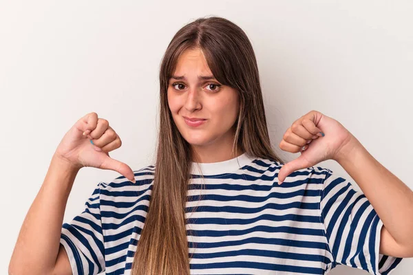 Beyaz arka planda izole genç beyaz kadın baş parmağını aşağı gösteriyor, hayal kırıklığı konsepti.