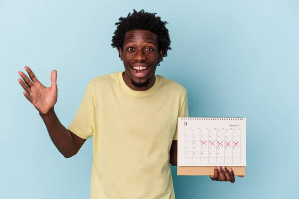 Jonge Afro Amerikaanse Man Houdt Kalender Geïsoleerd Blauwe Achtergrond Ontvangen — Stockfoto