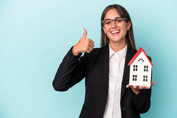 Jovem Mulher Negócios Segurando Brinquedo Casa Isolado Fundo Azul Sorrindo — Fotografia de Stock