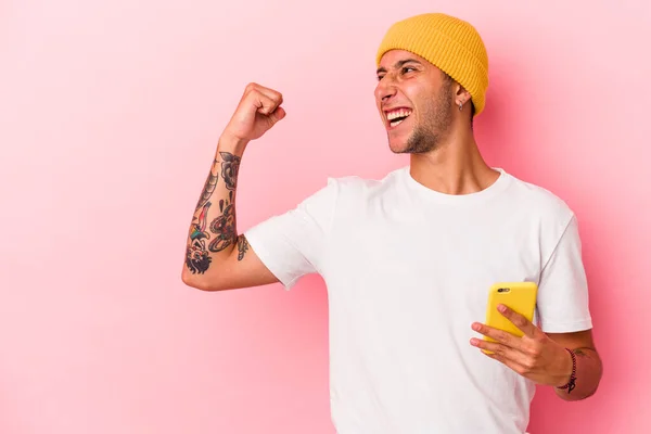 Joven Hombre Caucásico Sosteniendo Teléfono Móvil Aislado Sobre Fondo Rosa —  Fotos de Stock