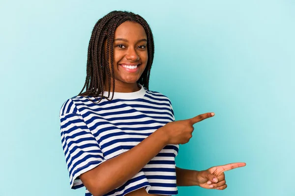 被蓝色背景隔离的年轻的非洲裔美国女人兴奋地伸出食指 — 图库照片