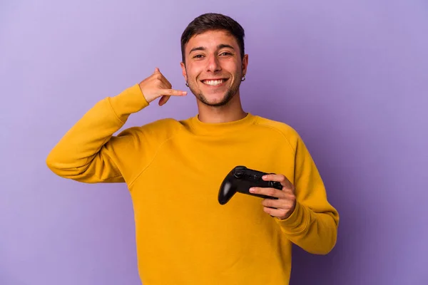 Young Caucasian Man Holding Game Controller Isolated Purple Background Showing —  Fotos de Stock