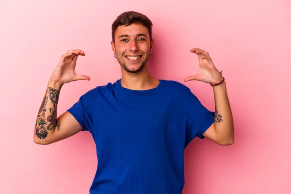 Jovem Caucasiano Com Tatuagens Isoladas Fundo Amarelo Segurando Algo Com — Fotografia de Stock