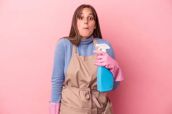 Junge Kaukasische Putzfrau Mit Spray Auf Rosa Hintergrund Zuckt Mit — Stockfoto