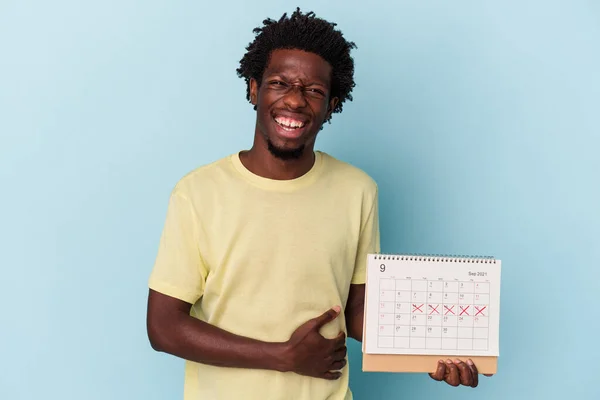 Jonge Afrikaanse Amerikaanse Man Houden Kalender Geïsoleerd Blauwe Achtergrond Lachen — Stockfoto
