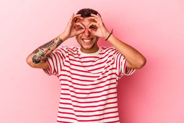 Sarı arka planda izole edilmiş beyaz dövmeli genç bir adam heyecanlı..