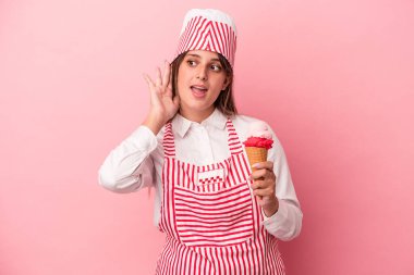 Dondurmacı kadın pembe arka planda izole edilmiş dondurma tutuyor. Dedikoduları dinliyor..