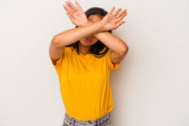 Beyaz arka planda izole edilmiş genç Latin kadın iki kolu çapraz tutuyor, inkar kavramı.