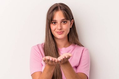 Beyaz arka planda izole edilmiş beyaz bir kadın elinde avuç içi bir şeyle kameraya sunuyor..