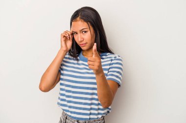 Beyaz arka planda izole edilmiş genç Latin bir kadın parmağıyla tapınağı işaret ediyor, düşünüyor ve bir göreve odaklanıyor..