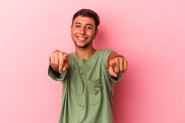 Sarı arka planda izole edilmiş dövmeli beyaz bir adam. Önü işaret eden neşeli gülümsemeler..