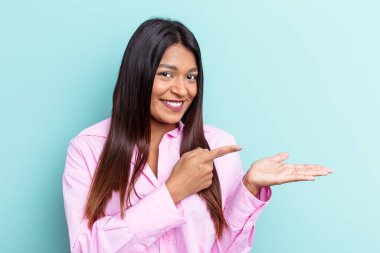 Venezuelalı genç bir kadın mavi arka planda izole edilmiş..