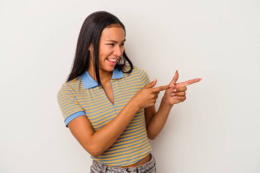 Beyaz arka planda izole edilmiş genç Latin kadın başparmak uzakta, gülüyor ve kaygısız.