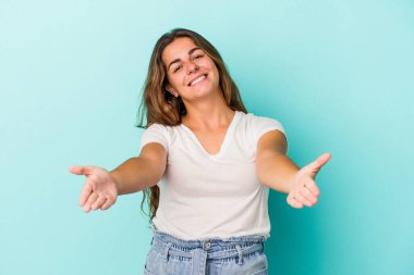 Mavi arka planda izole edilmiş beyaz bir kadın hoş bir ifade sergiliyor..