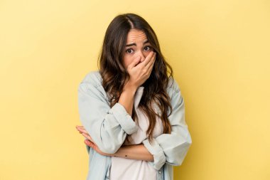 Sarı arka planda izole edilmiş genç beyaz kadın korkmuş ve korkmuş..