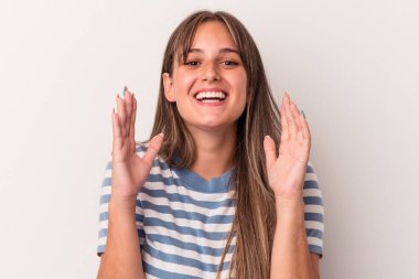 Beyaz arka planda izole genç beyaz kadın yüksek sesle gülüyor elini göğsüne koyuyor..