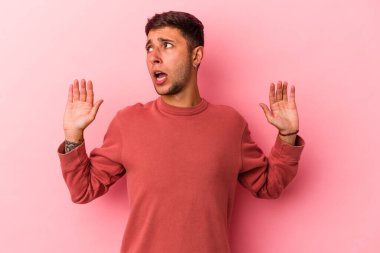 Sarı arka planda dövmeleri olan beyaz bir genç yakın bir tehlike nedeniyle şoka uğruyor.