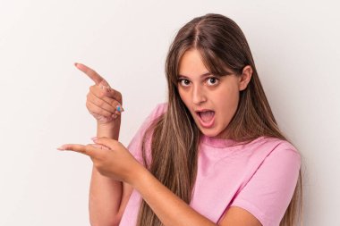 Beyaz arka planda izole edilmiş genç beyaz kadın işaret parmaklarıyla fotokopi alanını işaret ederek heyecan ve arzusunu ifade ediyor..