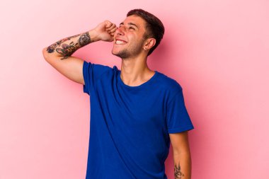 Sarı arka planda izole edilmiş dövmeleri olan genç beyaz adam zaferi, tutkuyu ve coşkuyu kutluyor..