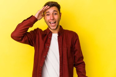 Sarı arka planda izole edilmiş beyaz dövmeli genç adam yüksek sesle bağırıyor, gözleri açık ve elleri gergin tutuyor..