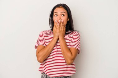 Beyaz arka planda izole edilmiş genç Latin bir kadın. Bir fotokopi odasına dikkatlice bakıyor. Ağzını eliyle kapatıyor..