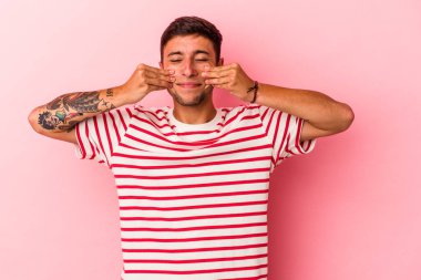 Sarı arka planda dövmeleri olan beyaz bir adam iki seçenek arasında kuşkulanıyor..