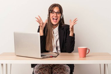 Beyaz arka planda bir zaferi ya da başarıyı kutlamak için evden işe giden beyaz saçlı genç kadın şaşırdı ve şok oldu..